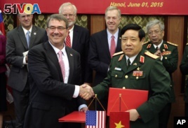 U.S. Defense Secretary Ash Carter, front  left, shakes hands with his Vietnamese counterpart Gen. Phung Quang Thanh, front right, after the two signed a joint vision statement between the two defense ministries in Hanoi, Vietnam Monday, June 1, 2015. (AP Photo/Tran Van Minh)