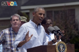 Senator David Vitter, left, watches as President Obama speaks in Baton Rouge.