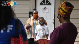 n this Friday, June 5, 2020 photo, Titilaya Thompson and her son Nehemiah talk with Dr. Tayarisha Batchelor, right, and Community School Director for The Village for Families and Children Trisila Tirado, left, in Hartford, Conn. (AP Photo/Jessica Hill)