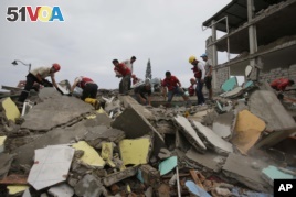 Volunteers search for survivors in buildings destroyed by an earthquake in Pedernales, Ecuador, Sunday, April 17, 2016. 