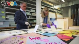 Jan Ramirez, chief curator at the 9/11 Memorial & Museum, right, sifts through a collection of condolence cards for a victim of 9/11 that were donated to the museum's archive, July 16, 2021, in Jersey City, New Jersey. (AP Photo/Robert Bumsted)