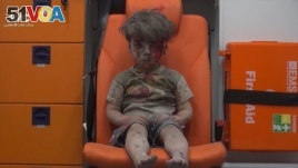 In this frame grab taken from video provided by the Syrian anti-government activist group Aleppo Media Center (AMC), a child sits in an ambulance after being pulled out or a building hit by an airstirke, in Aleppo, Syria, Aug. 17, 2016. 
