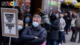 FILE - People wait in line at a COVID-19 testing site in Times Square, New York City, Dec. 13, 2021. Omicron has raced ahead of other variants and is now the dominant version of the coronavirus in the United States.