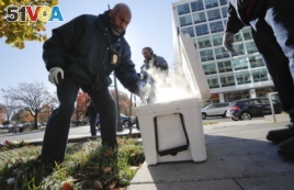 Pest Control Officers Gregory Cornes, left, uses a hand trowel to scoop-up dry ice before dropping it directly into rat burrows, as his co-worker Curtis Redman assist, near the Capitol building in Washington, Wednesday, Nov. 21, 2018. (AP Photo)