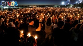 FILE - People attend a candlelight vigil the day after a shooting at Marjory Stoneman Douglas High School in Parkland, Florida, U.S., February 15, 2018. 