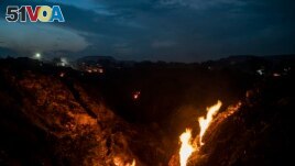 Flames rise out of the fissures on the ground above coal mines in the village of Liloripathra near Dhanbad, an eastern Indian city in Jharkhand state, Sept. 23, 2021. (AP Photo/Altaf Qadri)