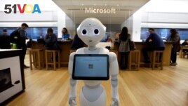 In this Sunday, March 21, 2019 photo a robot called Pepper is positioned near an entrance to a Microsoft Store location, in Boston. (AP Photo/Steven Senne)