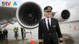 Richard de Crespigny, the pilot who was responsible for safely landing a damaged Qantas Airbus plane in 2010, stands in front of the engine (AP Photo/Wong Maye-E)