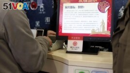A sign of China's digital yuan, or e-CNY, is seen during a trial of the Digital Currency Electronic Payment (DCEP) at a store in Beijing. Central banks are seeking ways to digitize currency. (REUTERS/Florence Lo)