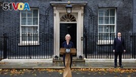 British Prime Minister Liz Truss announces her resignation, as her husband Hugh O'Leary stands nearby, outside Number 10 Downing Street, London, Britain October 20, 2022. (REUTERS/Henry Nicholls)
