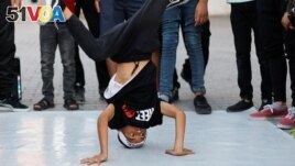 A Palestinian boy performs breakdance at a street in Nusseirat refugee camp in central Gaza Strip, October 14, 2022. (REUTERS/Ibraheem Abu Mustafa)
