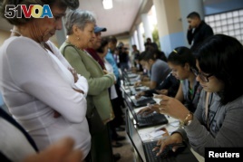People register to cast their vote at a polling station during a legislative election, in Caracas December 6, 2015. (REUTERS/Carlos Garcia Rawlins)