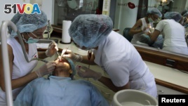 Two dentists work on an American patient at a dental clinic in San Jose, Costa Rica. REUTERS/Juan Carlos Ulate. 