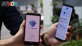 Government Technology Agency staff demonstrate Singapore's new contact-tracing smarthphone app called TraceTogether, as a preventive measure against the coronavirus in Singapore on March 20, 2020.