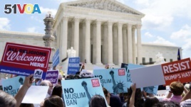 Protesters hold up signs and call out against the Supreme Court ruling upholding President Donald Trump's travel ban outside the the Supreme Court in Washington, Tuesday, June 26, 2018. (AP Photo/Carolyn Kaster)