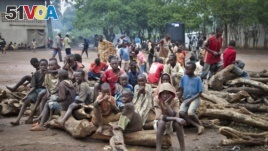 FILE - A group of Burundian refugee children sit on a pile of wood, at the Gashora refugee camp in the Bugesera district of Rwanda, April 21, 2015.