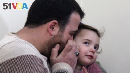 Syrian father Abdullah al-Mohammed whispers on the ear of his three-year-old daughter Salwa at their home in Sarmada, on February 19, 2020.