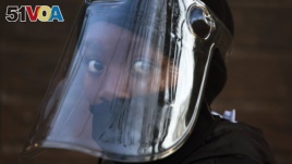 FILE — In this Aug. 24, 2020 file photo, a student, wearing a face mask and shield, returns to the Melpark Primary School in Johannesburg after several months of lockdown.