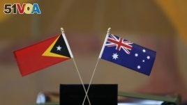 The flags of East Timor, left, and Australia are displayed during a ceremony at United Nations headquarters, Tuesday, March 6, 2018. Australia and East Timor signed a treaty that draws the first-ever maritime border between the neighbors.
