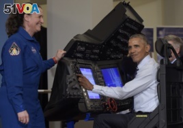 President Barack Obama sits in a flight simulator during a tour of projects at the White House Frontiers Conference at University of Pittsburgh in Pittsburgh, Oct. 13, 2016, as NASA astronaut Dr. Serena Aunon-Chancellor, left, watches.