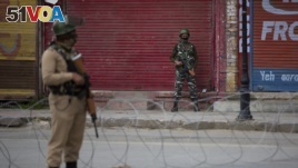 Indian paramilitary soldiers stand guard on a deserted road in Srinagar, Indian controlled Kashmir, Wednesday, May 6, 2020. Government shut down cellphone and nd mobile internet services after anti-India protests, officials, and residents said. (AP Photo/ Dar Yasin)
