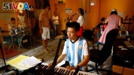 Zu Wenbao, 23, plays the keyboard during a practice session with his band Star Kids, who like him are all adults with autism spectrum disorder. (REUTERS/Tingshu Wang)