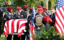 FILE - An honor guard carries the coffin of U.S. Army Sergeant La David Johnson, who was among four special forces soldiers killed in Niger, at a graveside service in Hollywood, Florida, Oct. 21, 2017.