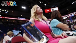 Dana Dougherty from Deltona, Fla., watches as she holds a Donald Trump figure during first day of the Republican National Convention in Cleveland, Monday, July 18, 2016. (AP Photo/Carolyn Kaster)