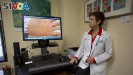 Dermatologist Dr. Anne Burdick checks the computer screen in her Miami office, as she discusses telemedicine, 2014. (AP Photo/J Pat Carter)