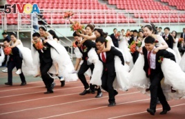 Couples take part in a competition during a mass wedding of 64 doctoral student couples at Harbin Institute of Technology, a university in Harbin, Heilongjiang province, China, June 4, 2017.