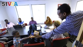 FILE - Somali immigrant leader Jamal Dar, right, who arrived in the U.S. two decades ago from Kenya, hands out snacks to a boy at a community engagement and civic language class for former Somali residents in East Portland, Oregon, July 21, 2015.