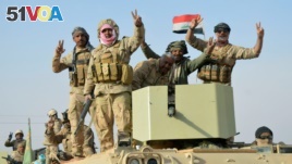 Iraqi forces show victory signs after they captured Rawa town, the last remaining town under Islamic State control, Nov. 17, 2017. 