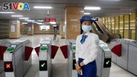 An attendant stands near turnstiles at Lang station in Hanoi, Vietnam, Nov. 6, 2021, on opening day of the city's first urban metro train running along the Cat Linh-Ha Dong line. (Photo by Nhac NGUYEN / AFP)