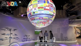 A globe with the national flags hangs in one of the pavilions at the UN Climate Conference in Bonn, Germany, Tuesday, Nov. 7, 2017. (Oliver Berg/dpa via AP)