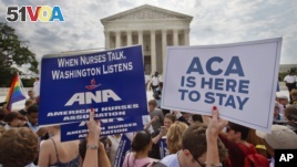 Supporters of the Affordable Care Act hold up signs as the opinion for health care is reported outside of the Supreme Court in Washington, June 25, 2015.  (AP Photo/Jacquelyn Martin)      