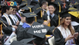 A graduating student wears a cap reading 