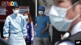 Hospital workers and visitors wearing masks to protect against the MERS, Middle East Respiratory Syndrome, virus at a quarantine tent in Seoul, South Korea June 3, 2015. (AP Photo/Ahn Young-joon)