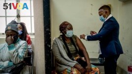 A woman is vaccinated against COVID-19 at the Hillbrow Clinic in Johannesburg, South Africa, Dec. 6, 2021. (AP Photo/ Shiraaz Mohamed)