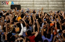 Supporters of Indian Prime Minister Narendra Modi use their mobile phones to take his picture as he addresses them after the election results at the Bharatiya Janata Party (BJP) headquarter in New Delhi, India, May 23, 2019.