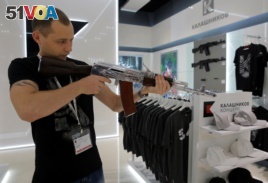 A salesperson demonstrates a model AK-47 assault rifle at the newly opened Gunmaker Kalashnikov souvenir store in Moscow's Sheremetyevo airport, Russia, August 22, 2016.