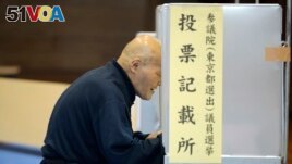 A voter selects candidates before casting a ballot in Japan's upper house parliamentary elections at a polling station in Tokyo, Sunday, July 10, 2016.