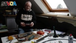 Guy Warein, a 70-year-old retiree, works on model trains in his home in Richebourg, northern France, Wednesday, Jan. 27, 2021. (AP Photo/Michel Spingler)