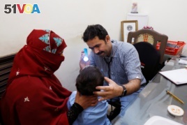 Dr Imran Akbar Arbani, performs a routine medical check-up of a four-year-old HIV positive boy, at clinic in Ratodero, Pakistan May 24, 2019. (REUTERS/Akhtar Soomro)