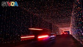 Passenger vehicles move through a tunnel of holiday lights at a display set up at the Cumberland Fair Grounds, Tuesday, Dec. 14, 2021, in Cumberland, Maine. (AP Photo/Robert F. Bukaty)