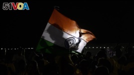 A spectator holds an Indian flag after a mission of Indian Space Research Organization's Chandrayaan-2, with the Geosynchronous Satellite Launch Vehicle on board was called back because of a technical snag in Sriharikota, India, July 15, 2019.