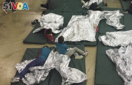 In this photo provided by U.S. Customs and Border Protection, people who've been taken into custody related to cases of illegal entry into the United States, rest in one of the cages at a facility in McAllen, Texas.