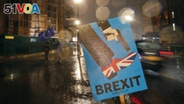 Vehicles drive past an anti-Brexit sign that is placed near the Parliament in London, Jan. 29, 2019.