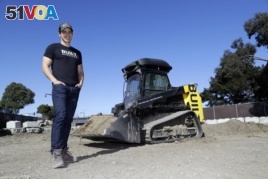 Built Robotics CEO Noah Ready-Campbell stands next to the company's self-driving track loader in San Francisco.