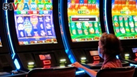 FILE - A woman plays a slot machine at the Golden Nugget casino in Atlantic City, New Jersey, July 2, 2020.