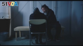 Ai Weiwei talks to refugee in scene from 'Human Flow' documentary.